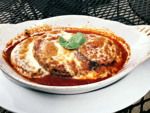 Eggplant Parmigiana covered in metled cheese and topped with sauce