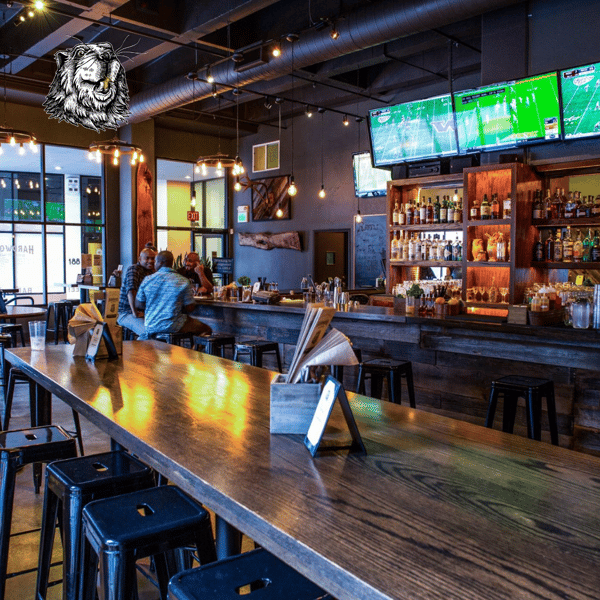 Industrial-chic bar interior at Hardwood Bar & Smokery in San Francisco featuring communal wood tables, craft beverages, and a lively atmosphere for private events and group gatherings