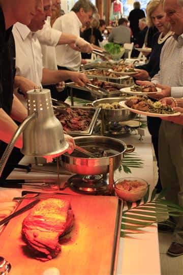 buffet station with a line of customers getting food