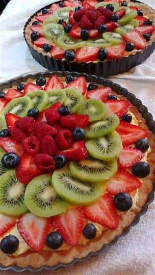 large dessert pie covered in sliced fruit