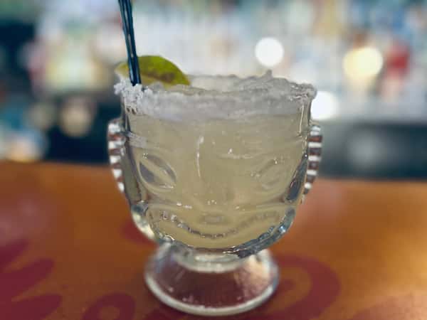 Margarita cocktail in a glass with a salted rim and a lime wedge garnish.