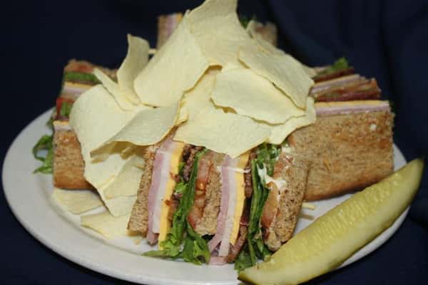 BLT sandwich sliced into quarters and covered in potato chips