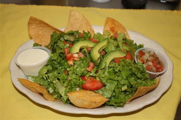 avocado salad with tortilla chips and sour cream and salsa sides