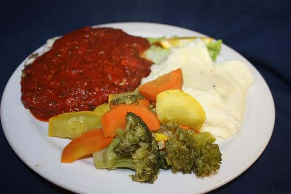 chicken parmesan covered in marinara sauce, with a side of mashed potatoes and steamed vegetables