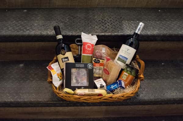 basket of wine bottles, cheese's, and pastries