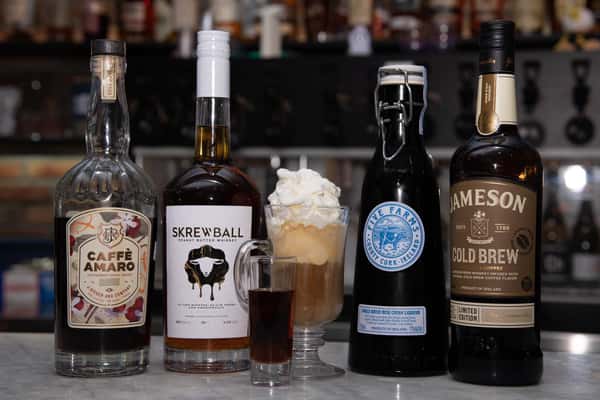 assortment of wine bottles and two glassed of dessert alcoholic drinks