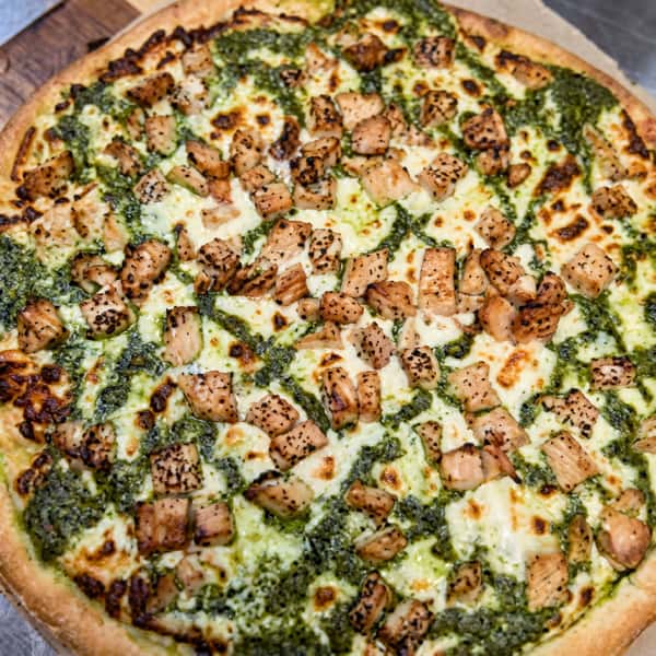 Pesto chicken pizza with chunks of chicken and melted mozzarella.