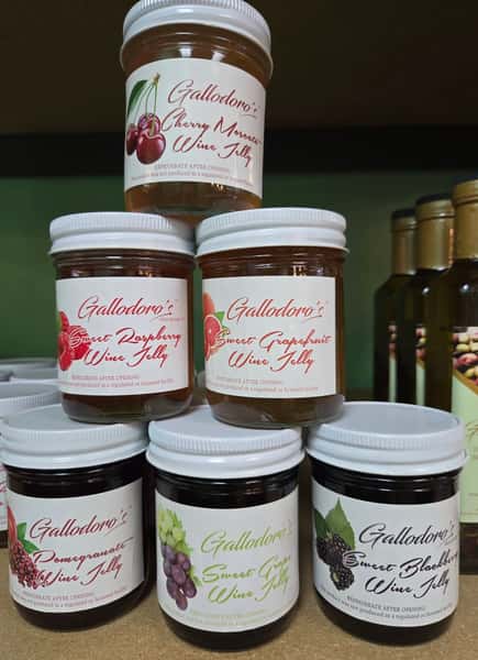 stacked jars of gourmet spreads and fruit preserves with colorful labels in a specialty food store