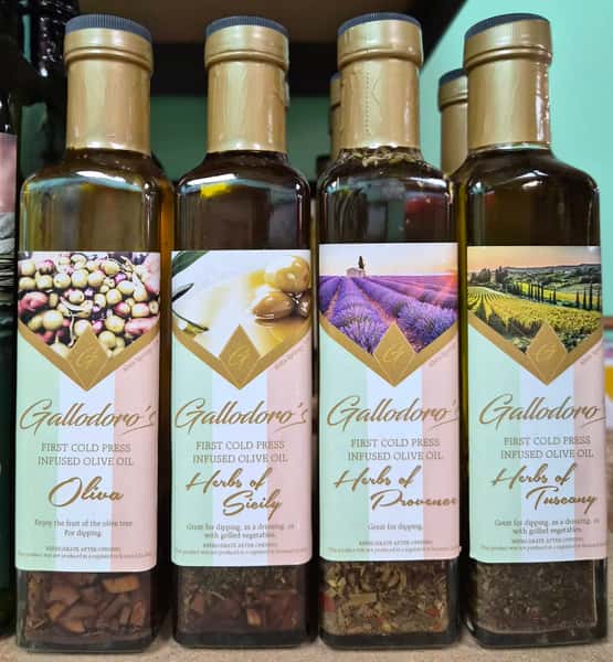 gourmet infused olive oils in glass bottles with herbs and garlic displayed on a shelf
