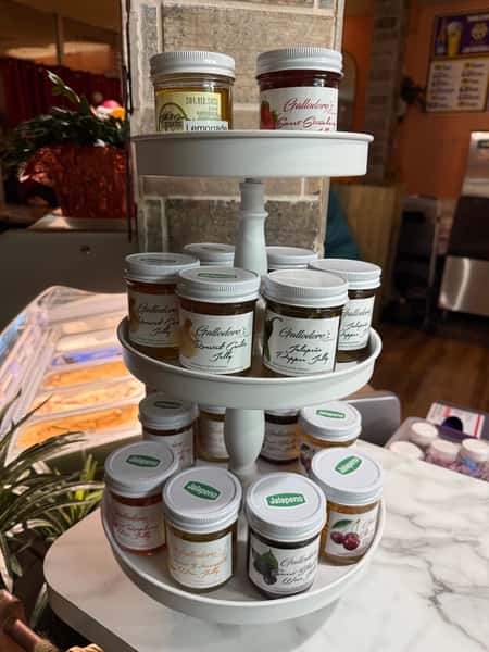 gourmet pickled vegetables and jarred goods displayed on a tiered stand in a specialty food shop