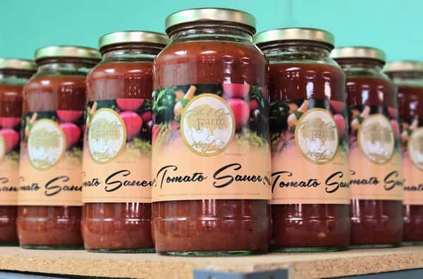 bottled salad dressings and marinades in various flavors lined up on a wooden shelf