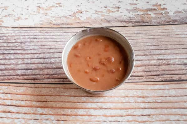 A bowl of creamy Southern pinto beans served on a wooden surface
