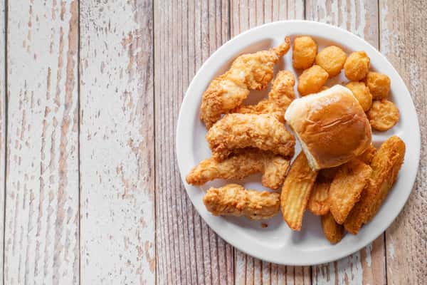 A plate of crispy golden chicken fingers served on a white plate