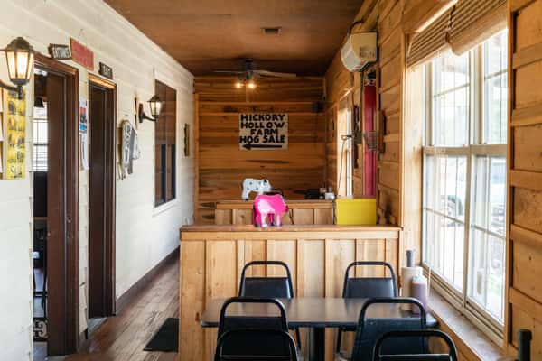 Warm restaurant dining area featuring wood-paneled walls, a decorative clock, and rustic decor