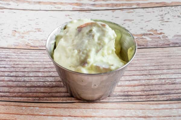 A bowl of creamy Southern-style potato salad on a wooden surface
