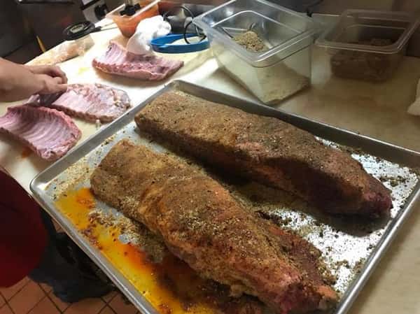 A pan with two slabs of cooked brisket on the kitchen counter