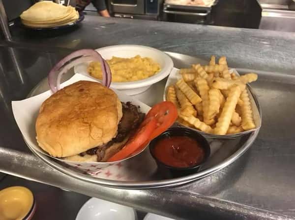 Platter with a burger served with crinkle fries, sauce and a side of mac and cheese