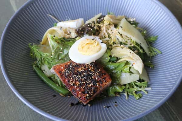 Ensalada de Salmón, a fresh salmon salad with greens and dressing, a light and flavorful dish at Zaranda Houston