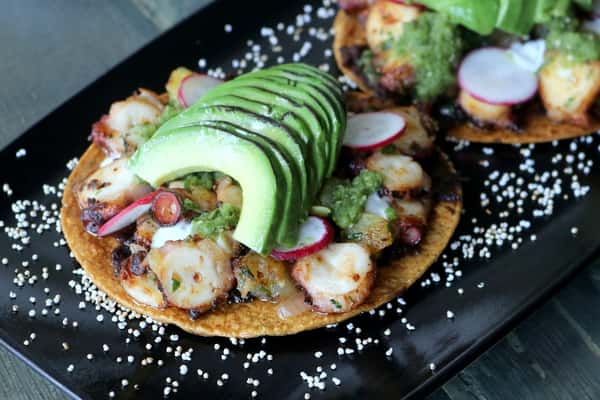 Tostadas de Pulpo – crispy tostadas topped with tender octopus, fresh avocado, and vibrant garnishes, a signature dish at Zaranda Houston