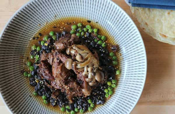 Borrego Tatemado slow-cooked lamb served on a blue plate with rich sauce, a bold specialty at Zaranda Houston