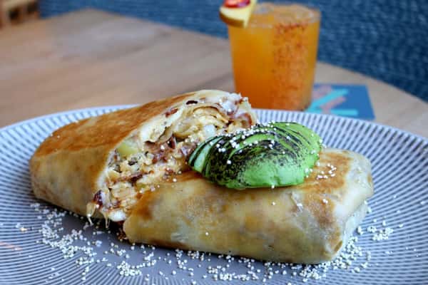 Baja Burrito stuffed with fresh ingredients and served with a drink, a coastal-inspired dish at Zaranda Houston