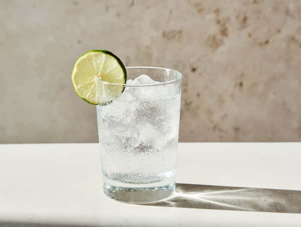 Sparkling lime soda served over ice in a clear glass with fresh lime garnish.