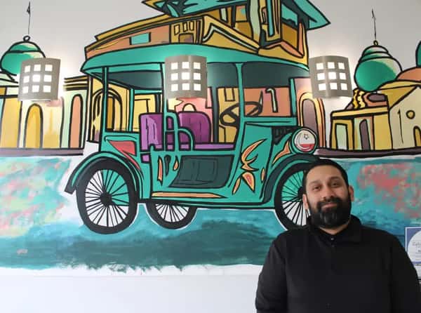 Team member standing in front of decorated wall