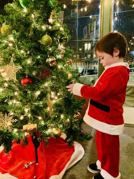 kid decorating the christmas tree