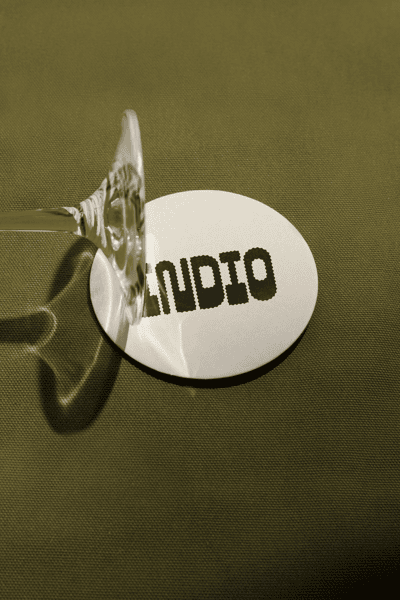Close up of Indio Brewing coaster with drinks glass
