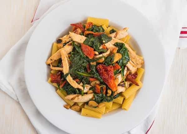 rigatoni topped with grilled chicken, spinach, and tomatoes
