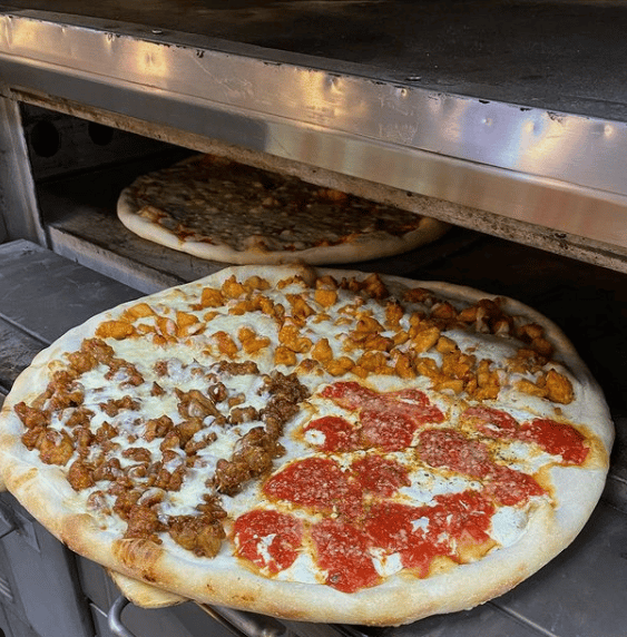 pizzas in a oven with toppings