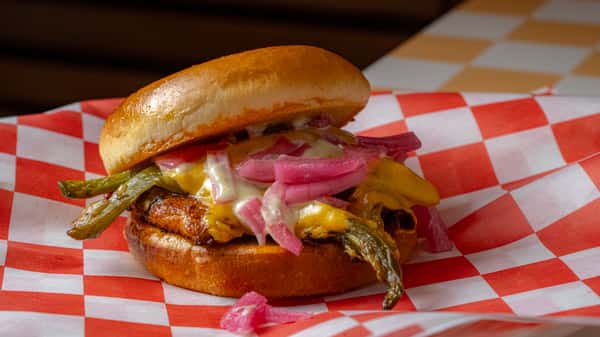 juicy cheeseburger topped with pickled onions and melted cheese on a toasted bun