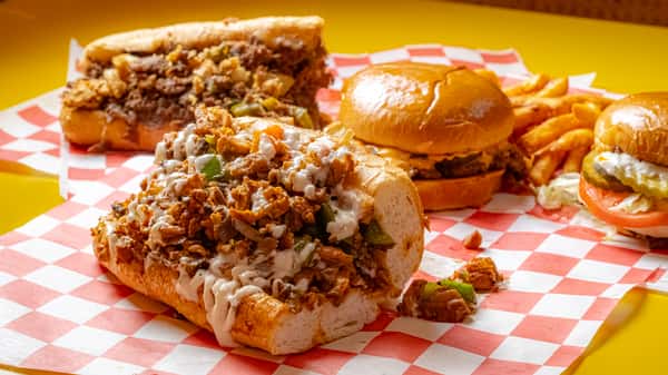cheesesteak sandwich loaded with chopped steak, melted cheese, and grilled onions on a toasted roll