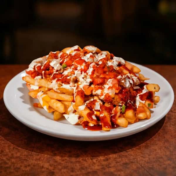 loaded fries topped with melted cheese, sauce, and savory toppings on a plate