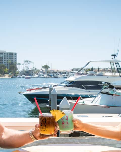 2 drinks clinking in front of Newport Beach