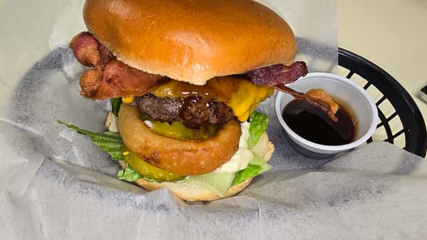 A burger with bacon lettuce and onion rings