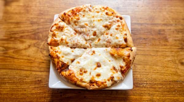 Small cheese pizza sliced into six wedges, served on a white square plate on a wooden table.