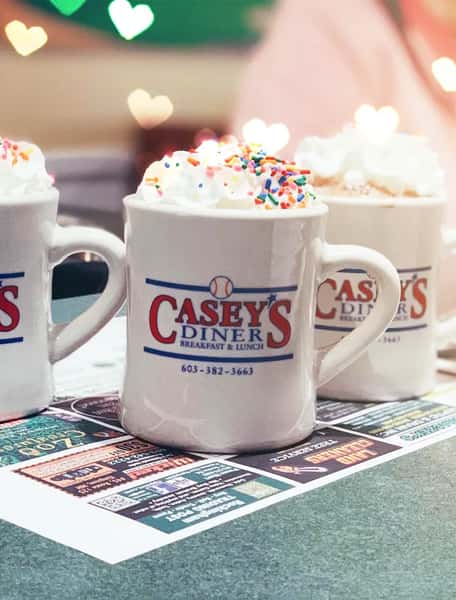 Three Casey's branded mugs on a table