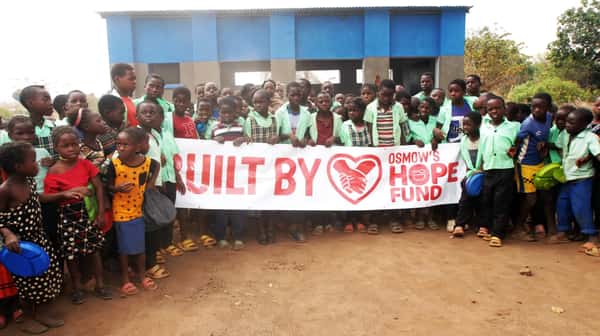 People holding a Built by Osmow's Hope Fund banner