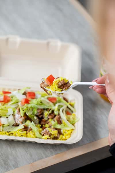 Hand holding a spoonful of food