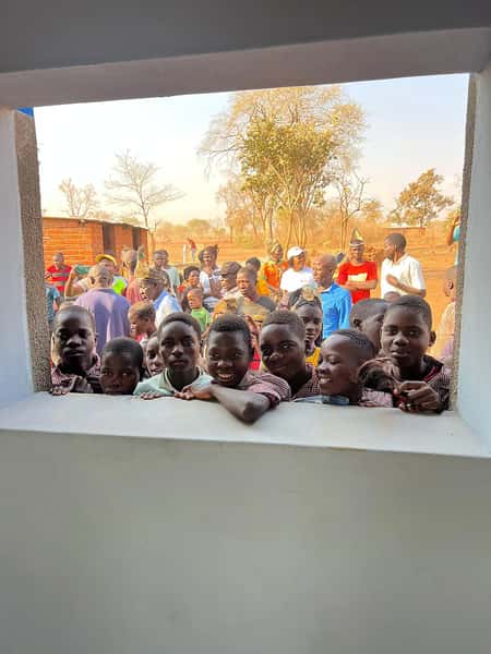 Smiling children standing in a window