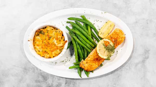 Coaches Corner: Golden salmon with lemon, vibrant green beans, and creamy baked mac and cheese served on a white plate.
