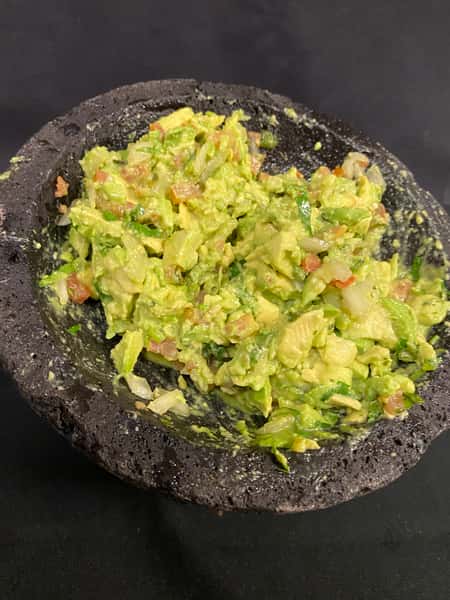 Fresh house-made guacamole prepared with ripe avocados, tomatoes, onions, cilantro, and lime, served in a traditional molcajete at Bobby Salazar's Mexican Restaurant & Cantina.