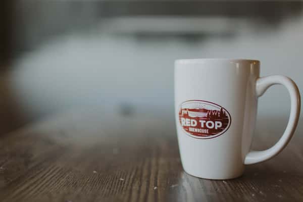 White porcelain coffee mug with oval Red Top logo