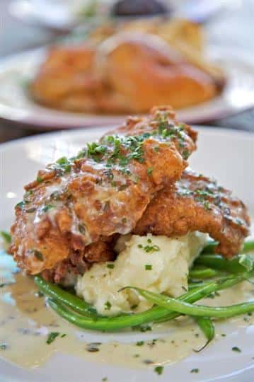 Fried chicken over mashed potatoes and green beans
