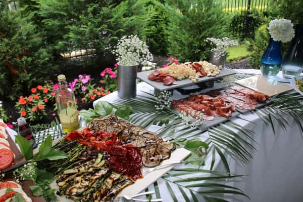 The buffet table at a catering event filled with trays of various dishes