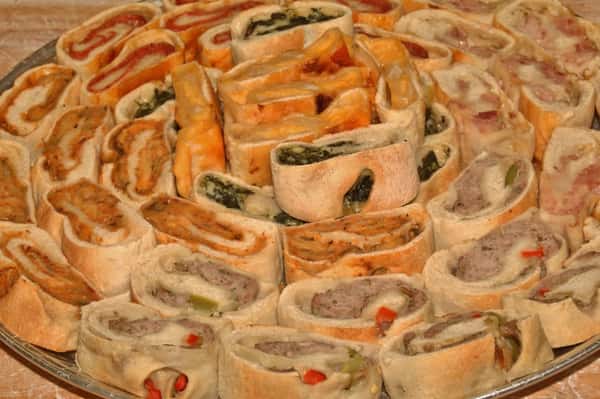 A tray full of stuffed bread. Half are stuffed with spinach and cheese, the other half is stuffed with roasted red peppers and mozzarella