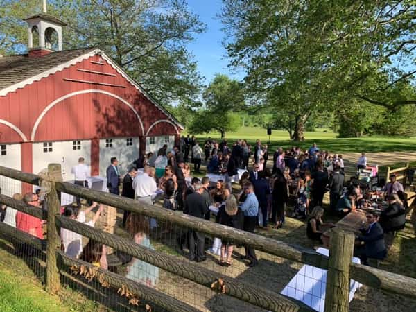 A catering event with guests dancing in front of the barn