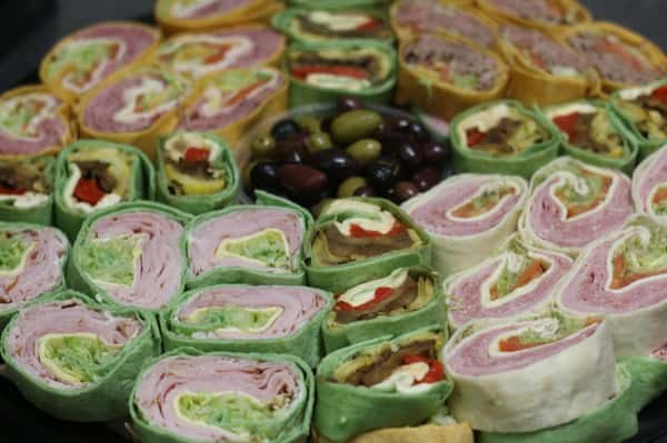 A tray filled with various pre-made sandwich wraps