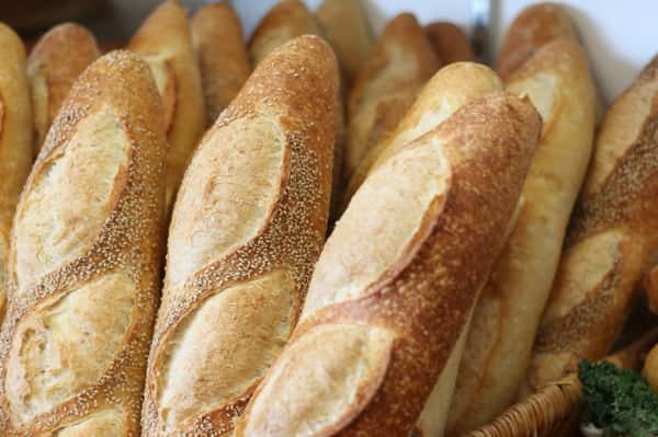 Many loafs of Italian bread in a basket